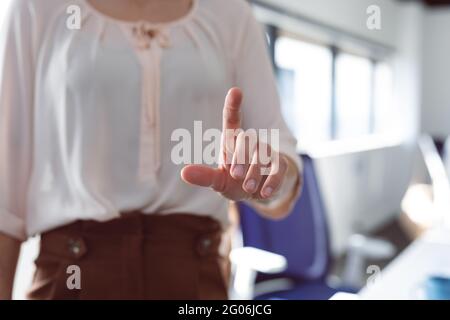 Close up of hand of caucasian businesswoman touching interactive screen Stock Photo