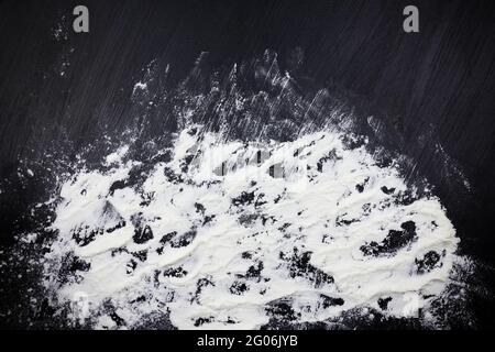 Sprinkled white flour on black surface Stock Photo