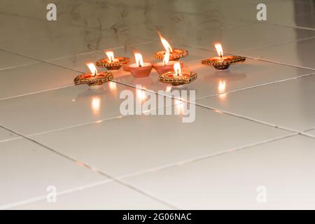 oil lamp or Diwali Diya also known as diva made of clay glowing decoration in diwali festival in front of flat. Diwali is biggest festival of India. Stock Photo