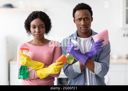 Comic black man and woman holding spray bottles as guns Stock Photo
