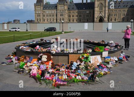 Ottawa, Canada. June 1st, 2021. A memorial to the 215 children found buried at a former Kamloops, British Columbia residential school laid at the Centennial Flame in front of the Canadian Parliament. People have been bringing kids shoes, stuffed animals and flowers to pay respect to the children whose bodies were uncovered in the grounds of the former Kamloops Indian Residential School as Canadians continue to wrestle with the history of Aboriginal Residential Schools throughout the country, as well as the historical treatment of First Nations communities. Credit: meanderingemu/Alamy Live News Stock Photo