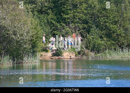 Ashford, Kent, UK. 01 Jun, 2021. UK Weather: Conningbrook lakes where people can come and enjoy the park and learn how to sail and paddle board. A group of young people by the lakeside. Photo Credit: Paul Lawrenson /Alamy Live News Stock Photo