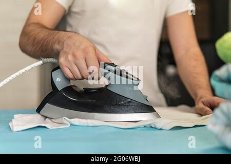 Home working, a man ironing his shirts at home Stock Photo