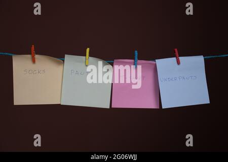 Sticky notes as a wardrobe on a rope with clothes pegs Stock Photo