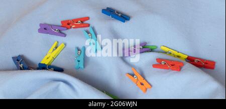 Clothespins scattered on a blue cloth Stock Photo