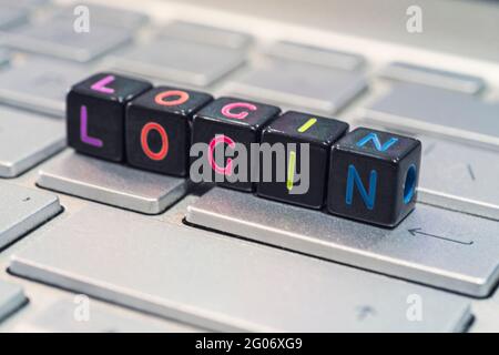 the word is login on the black cubes lying on the gray keyboard. The concept of information technology and the Internet. Stock Photo