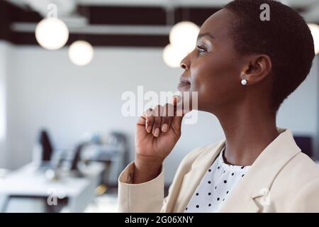 African american businesswoman thinking, touching chin at work Stock Photo