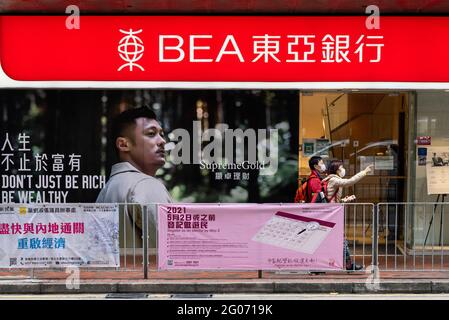 Pedestrians walk past the Bank of East Asia (BEA) branch and logo seen in Hong Kong. Stock Photo