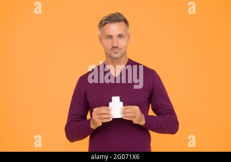 Body odor care. Handsome man hold lotion or bodywash bottle. Presenting personal hygiene care product. Shampoo or gel for hair care. Skin and body Stock Photo