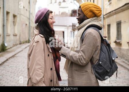 Multiethnic couple in warm clothing standing in the city Stock Photo