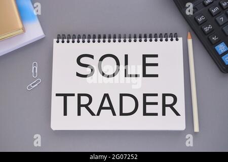 Sole trader on notepad with pencil, books and calculator. Business concept. Stock Photo