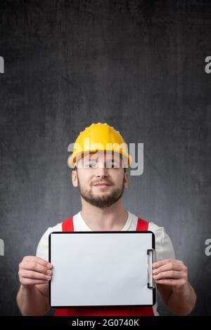 A worker showing a clipboard with blank paper Stock Photo