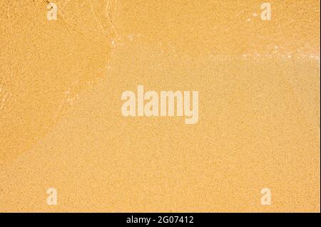 Closeup Of Wet Sand Texture Pattern On The Beach. Wave on clear sand beach. beach sand perfect plain texture background Stock Photo