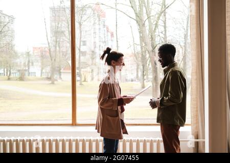 Two business colleagues standing in front of each other and discussing business report Stock Photo