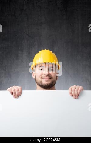 Construction worker holding a blank white board Stock Photo