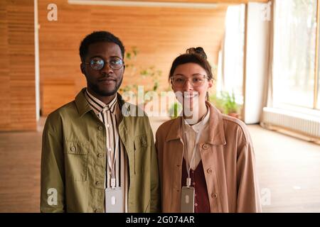 Portrait of two designers smiling at camera while standing at modern office Stock Photo