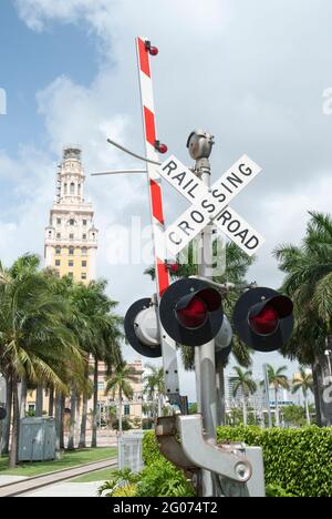 The open railroad crossing barrier and Miami historic Freedom Tower in a background (Florida). Stock Photo