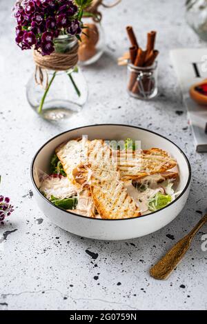 Bowl of chicken caesar salad on light background Stock Photo