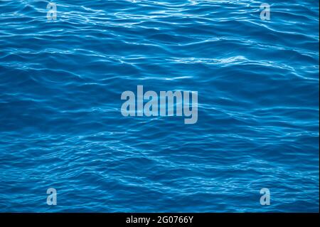 Blue sea water background texture. Abstract background. Waves of water of the river and the sea meet each other during high tide and low tide. Detaile Stock Photo