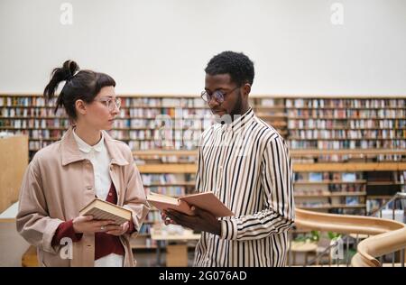 Young couple choosing books in the library Stock Photo
