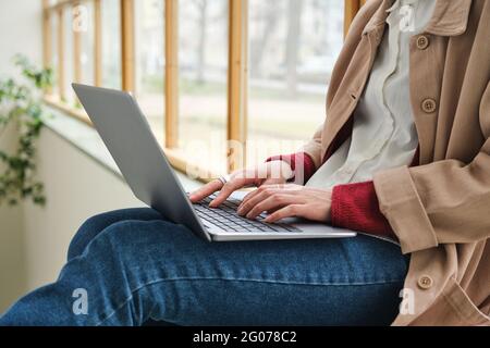 Close-up of young woman typing on computer and working online Stock Photo