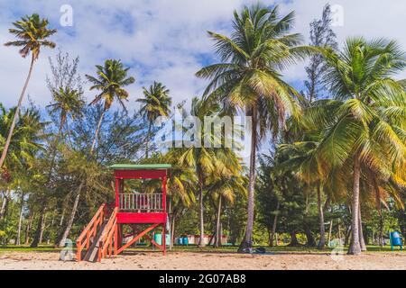 Red Life guard hut and palm trees on tropical beach. Luquillo Beach, Puerto Rico Stock Photo