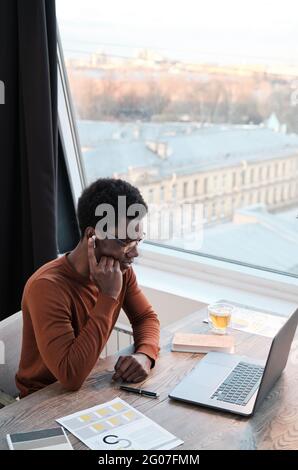 African man in headphones using computer for online conversation while working at office Stock Photo