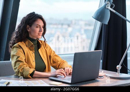 Young office worker typing on laptop computer she working at office Stock Photo