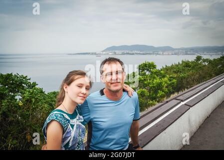 Portrait of travelers. A man and a teenage girl are sitting on vacation, hiking. The man is happy and smiling during the hike. Father and daughter in Stock Photo
