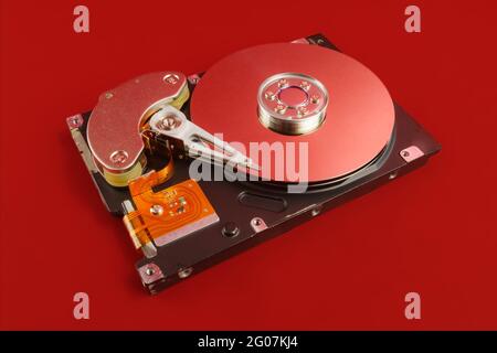Disassembled hard drive close up with plates visible on red background Stock Photo