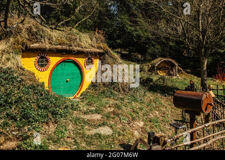 Hobbit house in Czech Hobbiton with three Hobbit holes and cute green doors.Fairy tale home in garden.Magic small village from fantasy movie located i