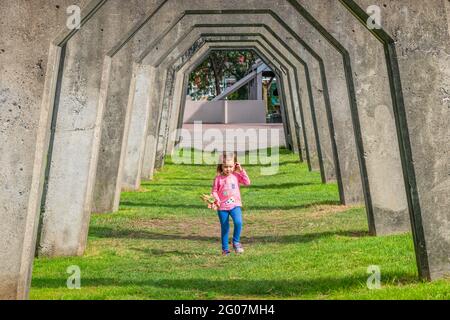 Little girl plays in Gas Works Park in Seattle Washington USA on a sunny day. Stock Photo
