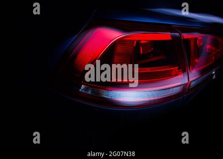 Car rear lights with glossy surface, red backlight of powerful sport sedan bodywork, concept. Stock Photo