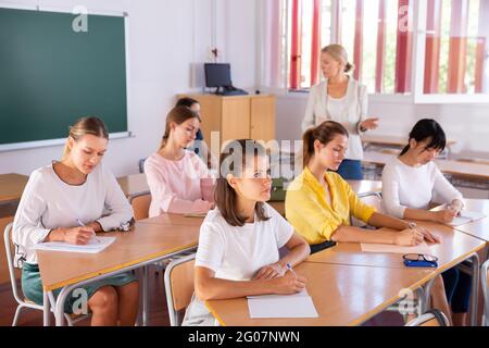 Students writing in notepads during lesson Stock Photo