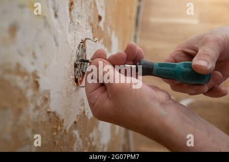 Hands of electrician installing electrical socket with new home Stock Photo