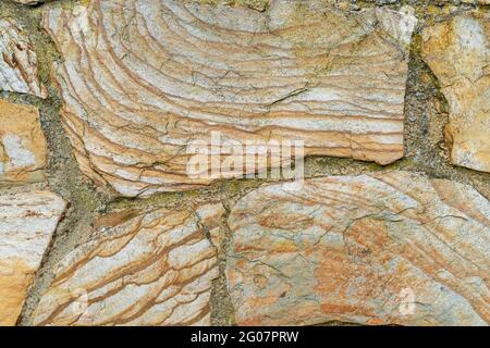 Layered texture of natural stones of an ancient wall. Abstract detailed brown background Stock Photo