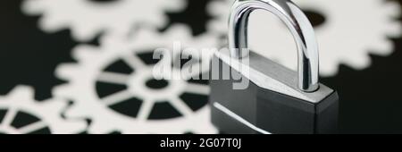 Black metal padlock standing on tablet screen closeup Stock Photo