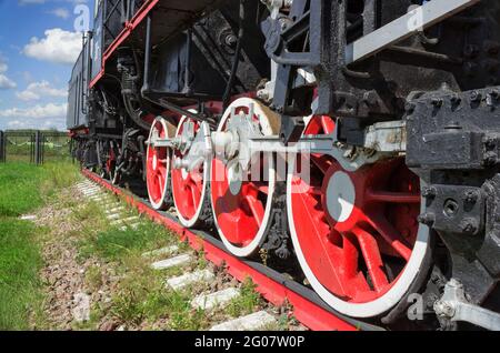 Wheels and coupling devices of a big old steam locomotive close-up Stock Photo