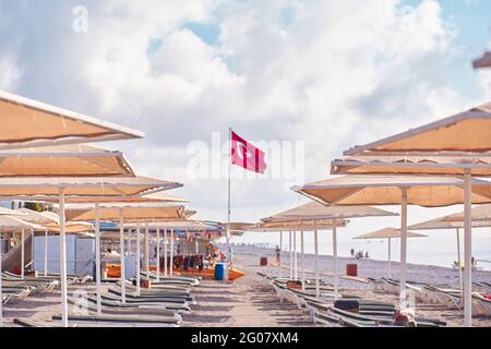 Kemer, Turkey - May, 21: Beach view of sunbeds, coast, sea on a bright sunny day. Turkish beach with Turkey flag. High quality photo Stock Photo