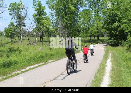 Mother with her two sons riding bicycles on the North Branch Trail at Miami Woods in Morton Grove, Illinois Stock Photo