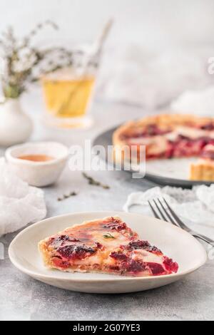 From above tasty fresh slice of quiche with red beet on white plate on served light table indoors Stock Photo
