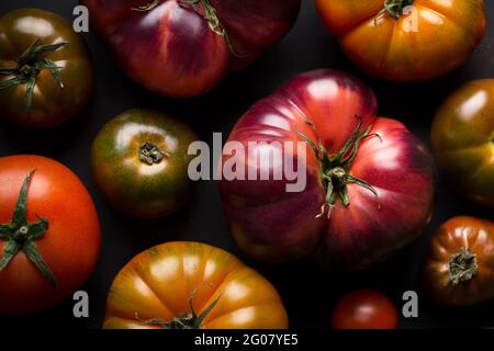 From above different fresh tomatoes on a black table Stock Photo