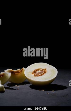 Side view of a fresh melon cut in half on black background Stock Photo