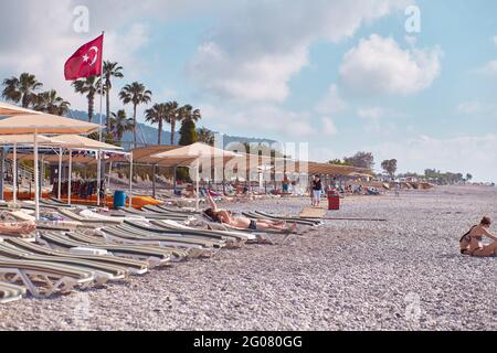 Kemer, Turkey - May, 21: Beach view of sunbeds, coast, sea on a bright sunny day. Turkish beach with Turkey flag. High quality photo Stock Photo