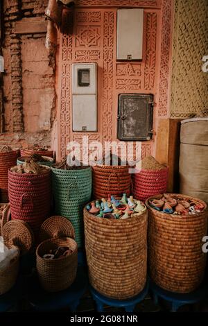 Wicker baskets with various ceramic wares placed outside ornamental building on street market in marrakesh, Morocco Stock Photo