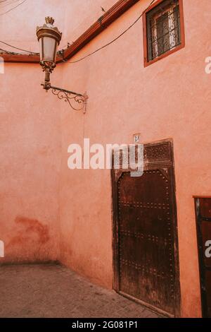 Crumbling wall of aged house with old door on street of Marrakesh, Morocco Stock Photo