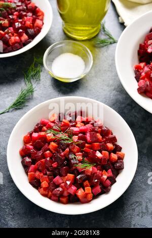 Beet salad in bowl. Healthy detox salad with beetroot, potato, carrot, pickles on blue stone background. Stock Photo