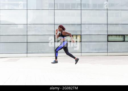 Ethnic Woman running on street Stock Photo