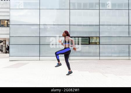 Ethnic Woman running on street Stock Photo