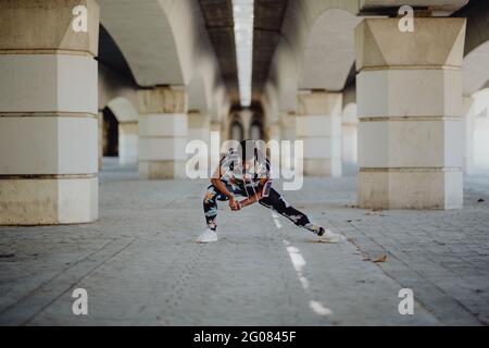 Young fitness African American Woman stretching legs before running on city street Stock Photo